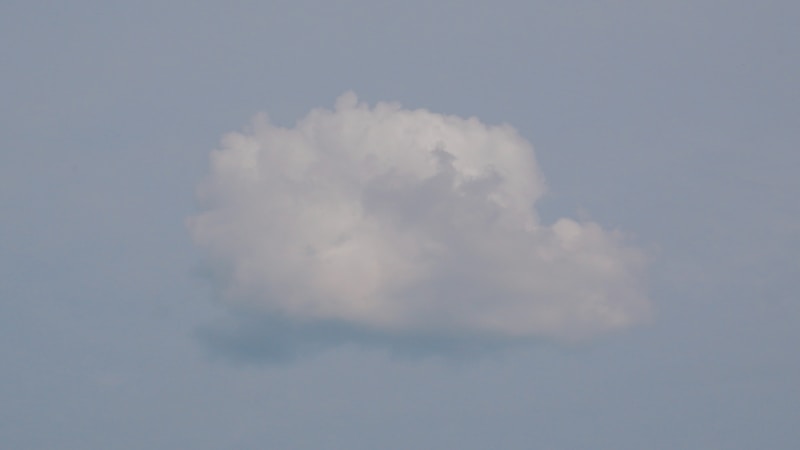 Single cumulus cloud against a pale-blue sky